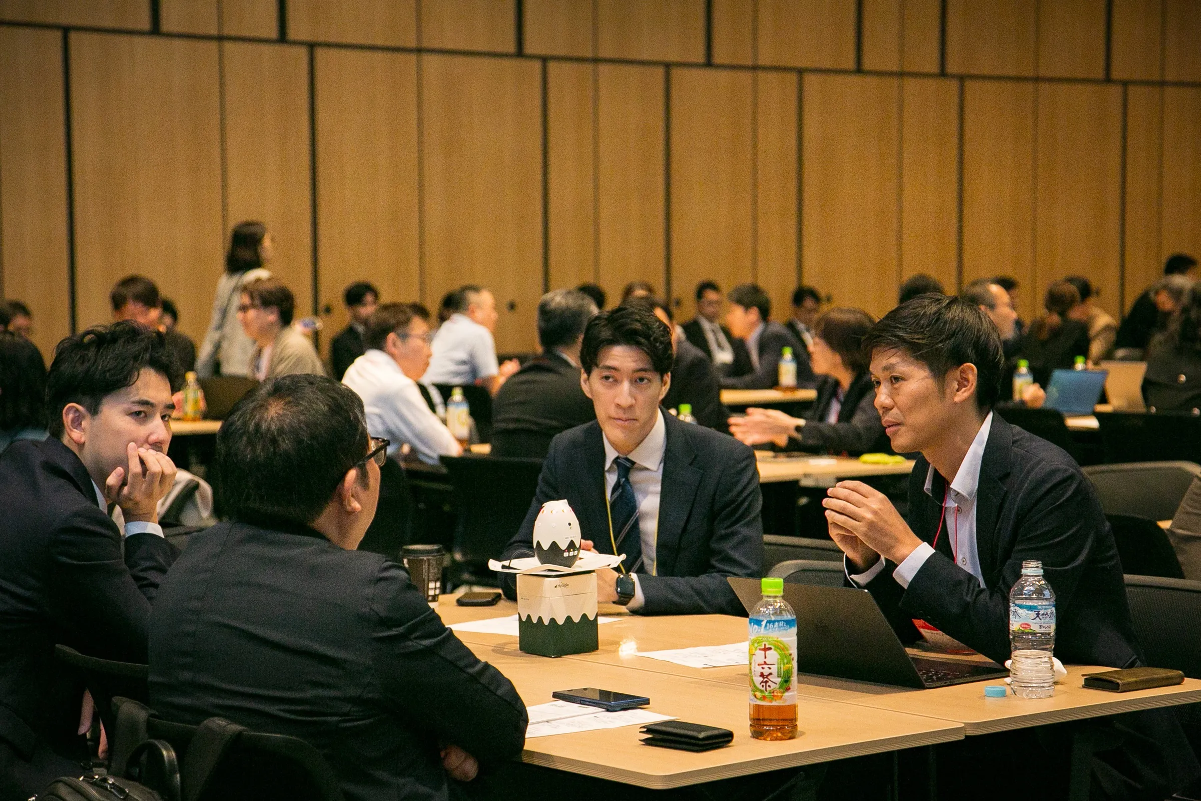 別のテーブルで参加者が資料を見ながら議論している様子